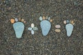 Steps of man, woman and kid made from stones on sandy beach. Royalty Free Stock Photo