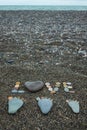 Steps of man, woman and kid made from stones on sandy beach. Royalty Free Stock Photo