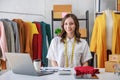 Concept of fashion and designer,Woman fashion designer stylish with measuring tape on neck sitting and smiling while workin about