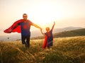 Concept of father`s day. dad and child daughter in hero superhero costume at sunset Royalty Free Stock Photo