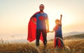 Concept of father`s day. dad and child daughter in hero superhero costume at sunset Royalty Free Stock Photo