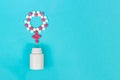 Concept Female health, female contraception. Venus Gender symbol made from pink and white pills with the bottle on light Royalty Free Stock Photo