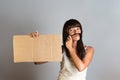 The concept of feminism and women`s rights. A woman holds a cardboard banner in her hands, imitating a man`s mustache on her fac