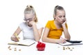 Concept of Finances. Pair of Caucasian Twin Teenage Girls With Notebooks Making Notes. With Stacks of Coins and Moneybox in