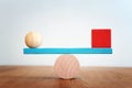 Concept of finding the right balance. Wooden balls and cubes on seesaw Royalty Free Stock Photo