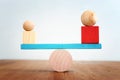Concept of finding the right balance. Wooden balls and cubes on seesaw Royalty Free Stock Photo