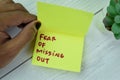 Concept of FOMO - Fear Of Missing Out write on sticky notes  on Wooden Table Royalty Free Stock Photo