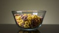 Concept of food and breakfast. Stock footage. Close up of colorful ring corn flakes in a transparent glass bowl on dark Royalty Free Stock Photo