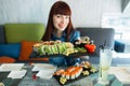 Concept of food, traditional Japanese dish. Likable girl enjoying tasty sushi in luxury restaurant. Female client