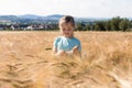 The concept of freedom and unity with nature. Summer vacation. Relaxation. A cute charming girl with long hair stands in a field