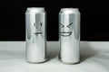 Concept of friends. Joke over a friend but it`s not funny. Aluminium cans with drowing emoticons, Emoji of laugh and poker face