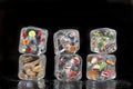 Concept of frozen products: fruits, vegetables, fishs, meat, spices herbs, pastry, were frozen inside ice cubes on black