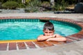 Oudoor summer activity. Concept of fun, health and vacation. A sad boy eight years old in swimming goggles is holding Royalty Free Stock Photo