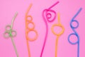 Concept of fun mood. Colorful cocktail straws on pink paper background. Plastic curved straws, tubes. Abstract frame, card with mi Royalty Free Stock Photo