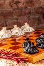 Concept of Georgian cuisine. black and white khinkali stand on a chessboard. female hand takes khinkali. khinkali with barina