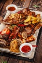 Concept of Georgian cuisine. Large meat board with shashlik, roasted meat, french fries, roast lamb and sauce. Serving dishes Royalty Free Stock Photo