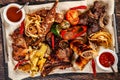 Concept of Georgian cuisine. Large meat board with shashlik, roasted meat, french fries, roast lamb and sauce. Serving dishes Royalty Free Stock Photo