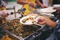 The concept of giving: Homeless people reach out to free volunteer meals from volunteers: help feed the hungry in society Royalty Free Stock Photo
