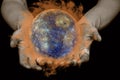 The concept of global warming. Male hands hold a burning globe on a black isolated background. Elements of this image