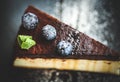 Concept of gluten-free cuisine. Vanilla cheesecake with wild berries in chocolate glaze with cocoa on a black slate background