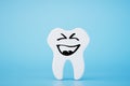 The concept of going to the dentist. tooth with emoticon painted on it. 3D render