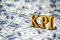 Concept gold abbreviation of KPI - Key Perfomance Indicator standing or lying on banknotes background. 3D Render.