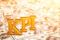 Concept gold abbreviation of KPI - Key Perfomance Indicator standing or lying on banknotes background. 3D Render.