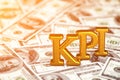 Concept gold abbreviation of KPI - Key Perfomance Indicator standing or lying on banknotes background. 3D Render.