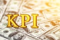 Concept gold abbreviation of KPI - Key Perfomance Indicator standing or lying on banknotes background. 3D Render.