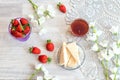 The concept of good morning. Ripe strawberries, airy waffles, white bells, a cup of tea , a gray napkin on a light background, top