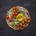 Concept of good nutrition, cherry tomatoes on a branch, rosemary, oil on a round cutting board wooden rustic background top vie Royalty Free Stock Photo