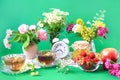 The concept of a good summer morning. Cups of tea among bouquets of wild flowers, strawberries in a cup, jars of jam, apples, Royalty Free Stock Photo