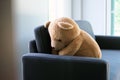 The concept of grief of children. The teddy bear sits on the couch inside the house, alone looking sad and disappointed Royalty Free Stock Photo