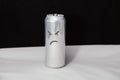 The concept of grumpy man. Angry emoticon on aluminium can, Emoji with rageful face. On black background Royalty Free Stock Photo