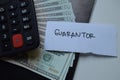 Concept of Guarantor write on sticky notes with dollar isolated on Wooden Table