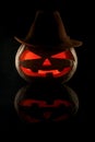 The concept of Halloween. Evil scary pumpkin cowboy in a hat in