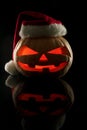 The concept of Halloween and the New Year and Christmas. The evil scary pumpkin Santa in the Santa Claus hat in the dark with ref Royalty Free Stock Photo