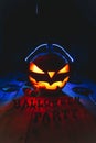 Concept of Halloween. Pumpkin jack Lamp, in headphones with CDs Royalty Free Stock Photo