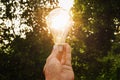 concept hand hold light bulb solar energy in nature