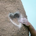 Concept the hand of a rock climber grabs a heart shaped grip Royalty Free Stock Photo