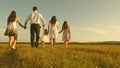 Concept of a happy childhood. mother, father and little daughter with sisters walking in field in the sun. Happy young Royalty Free Stock Photo