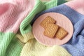 Concept happy colorful still life. Biscuit or cookies with knitted effect on colorful pastel plaid