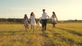 Concept of happy family. Children and mom are playing in meadow. mother and little daughter with sisters walking in park Royalty Free Stock Photo