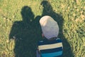 Concept of family. Shadows of parents, father and mother protect the child from the scorching sun.