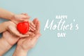 Concept Happy Mother`s Day or International Day of Families.Happy women`s day.Heart in the hands of daughter and mother on a blu