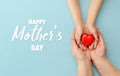 Concept Happy Mother`s Day or International Day of Families.Happy women`s day.Heart in the hands of daughter and mother on a blu