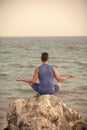 Concept of harmony. boy practicing yoga near blue ocean Royalty Free Stock Photo