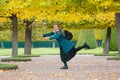 The concept of haste and tardiness. A woman is fooling around and having fun in the Park, against the background of yellow trees