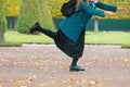 The concept of haste and tardiness. A woman is fooling around and having fun in the Park, against the background of yellow trees.