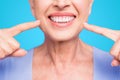 Concept of having strong healthy straight white perfect teeth at old age. Cropped portrait of beaming smile female Royalty Free Stock Photo